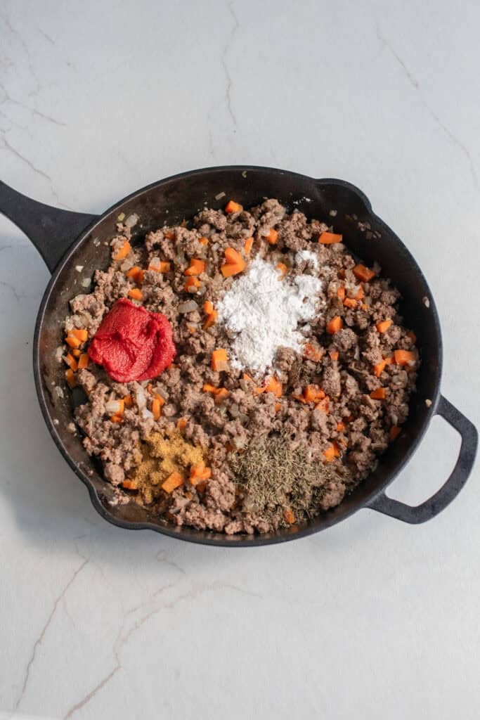 Ground beef and spices in a cast iron skillet.