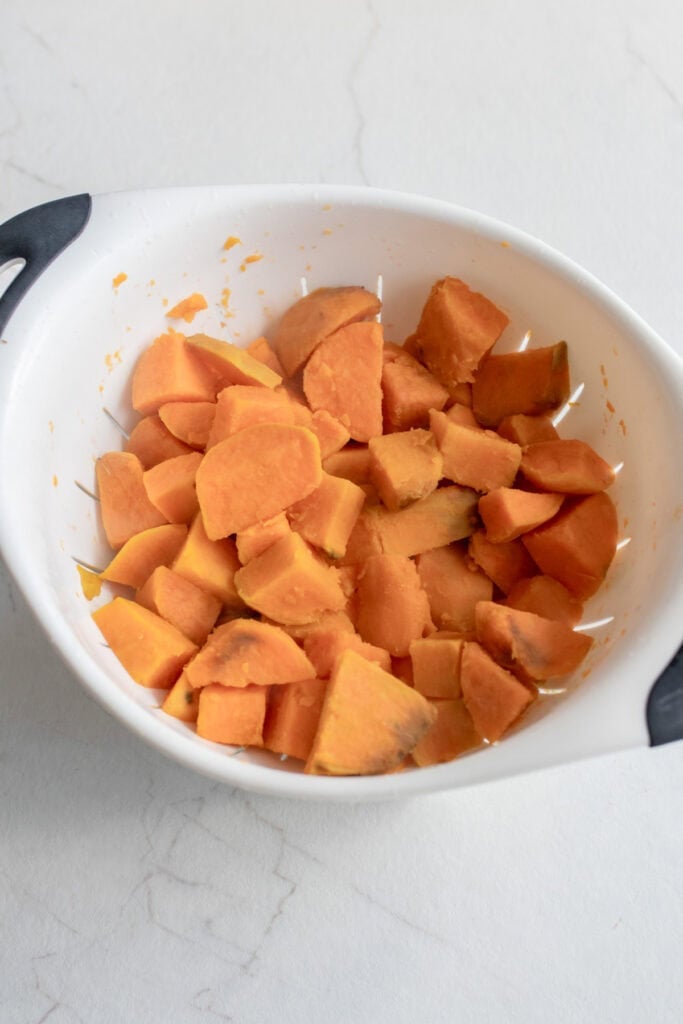 Peeled and chopped sweet potatoes in a bowl.