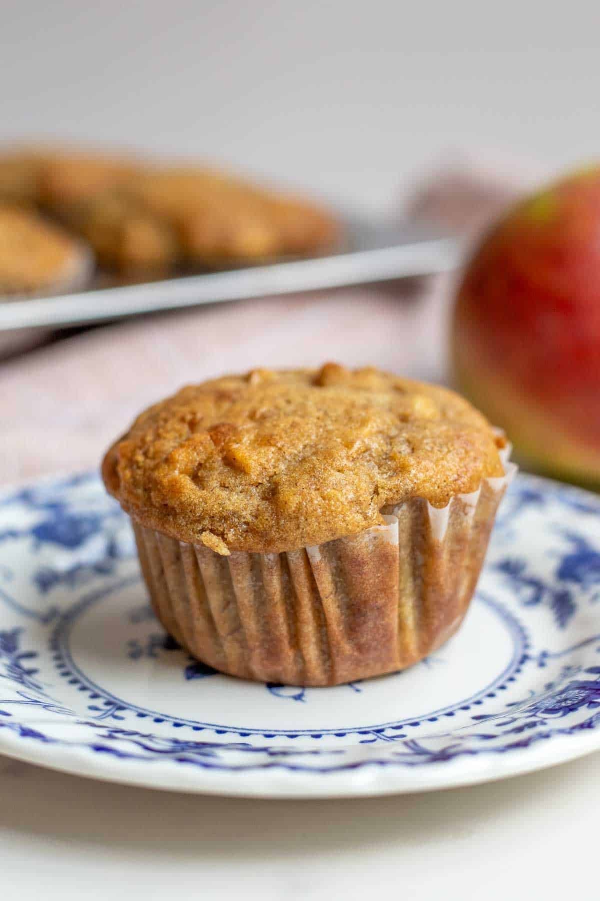 One apple banana muffin sitting on a blue decorative plate.