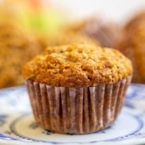 one apple carrot muffin on a small blue decorative plate.