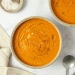 two bowls of carrot ginger soup on the counter.