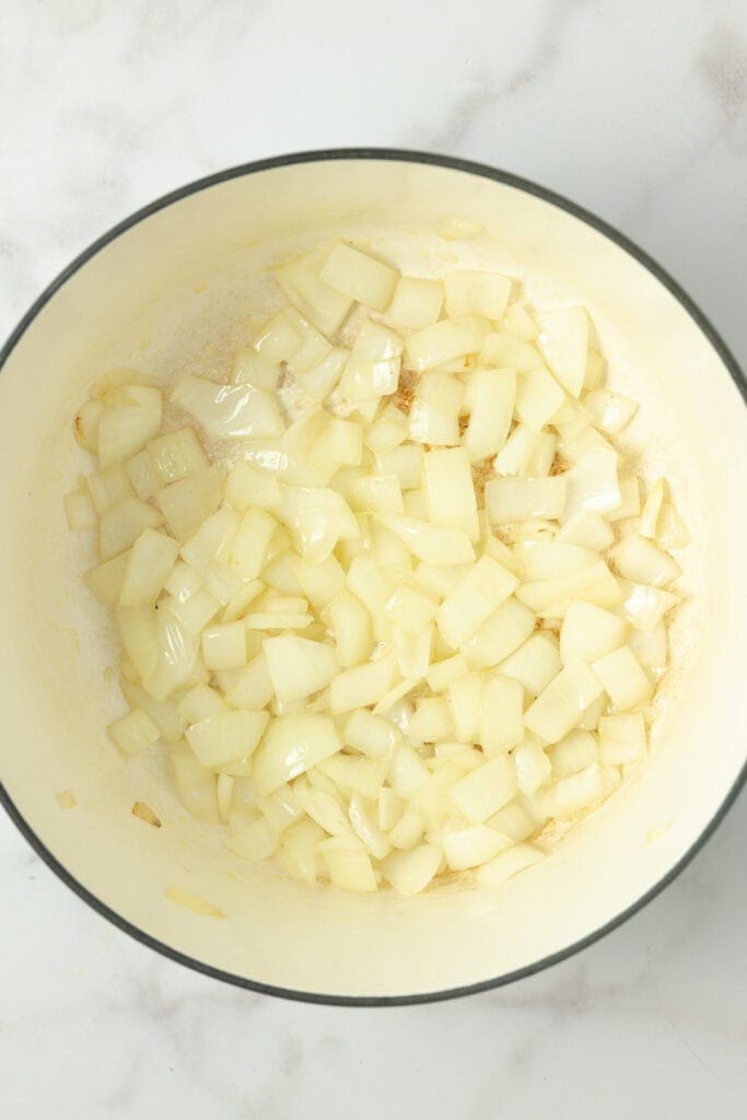 Onions cooking in a large stock pot on the stove.