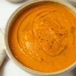 a finished bowl of carrot ginger soup on the kitchen counter.