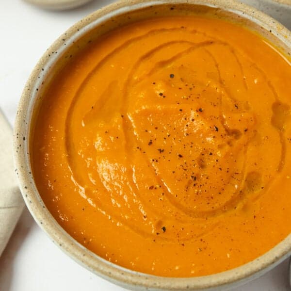 a finished bowl of carrot ginger soup on the kitchen counter.