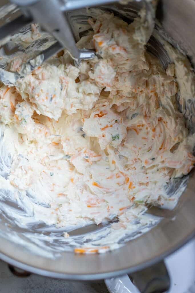 Cream cheese, cheddar cheese, seasonings and herbs mixed together in a stand mixer. 