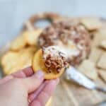 a piece of the cheese ball spread on a cracker.