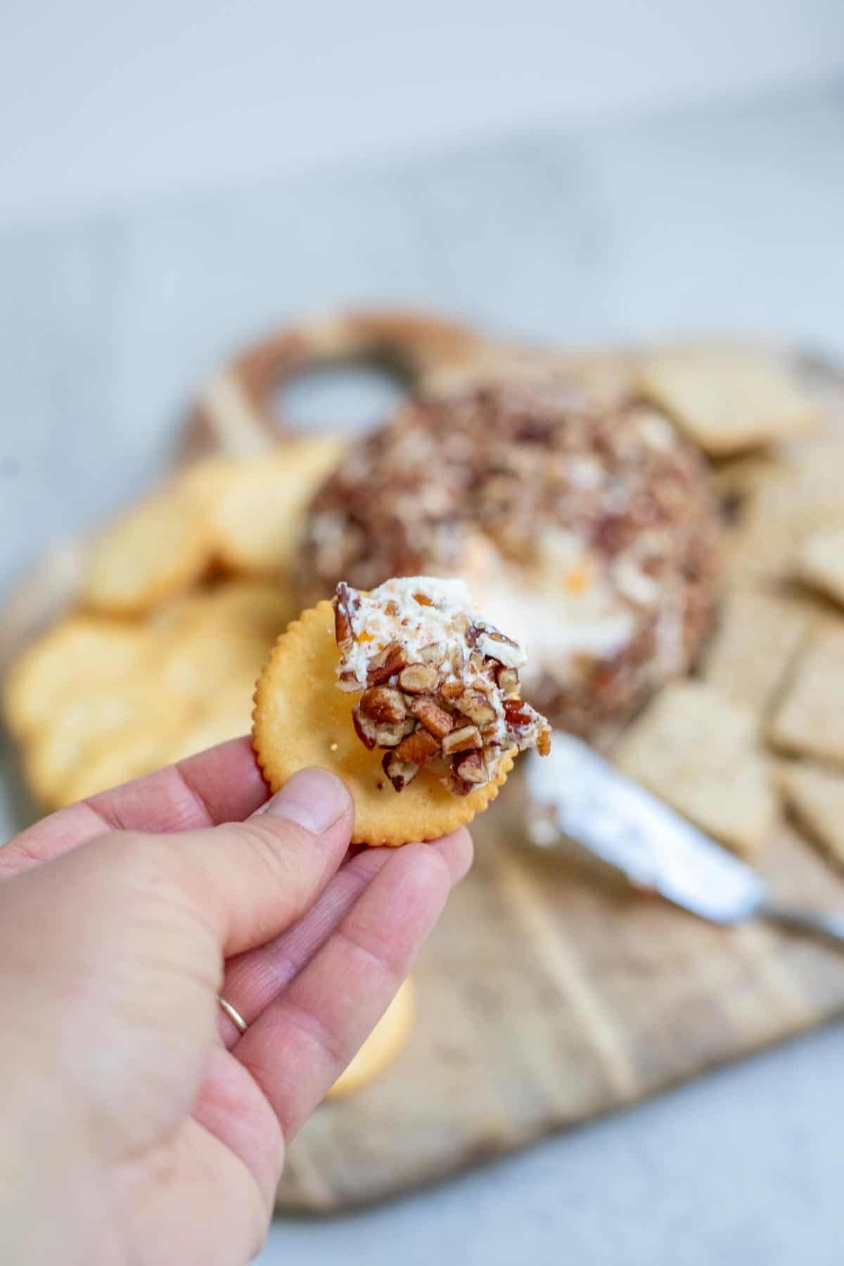 A piece of the cheese ball spread on a cracker.
