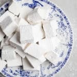 a pile of homemade marshmallows on a blue decorative plate.
