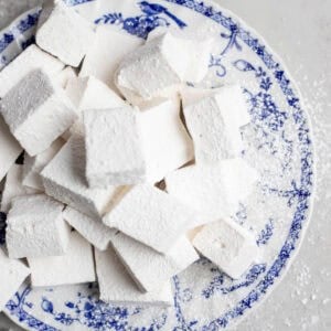 a pile of homemade marshmallows on a blue decorative plate.