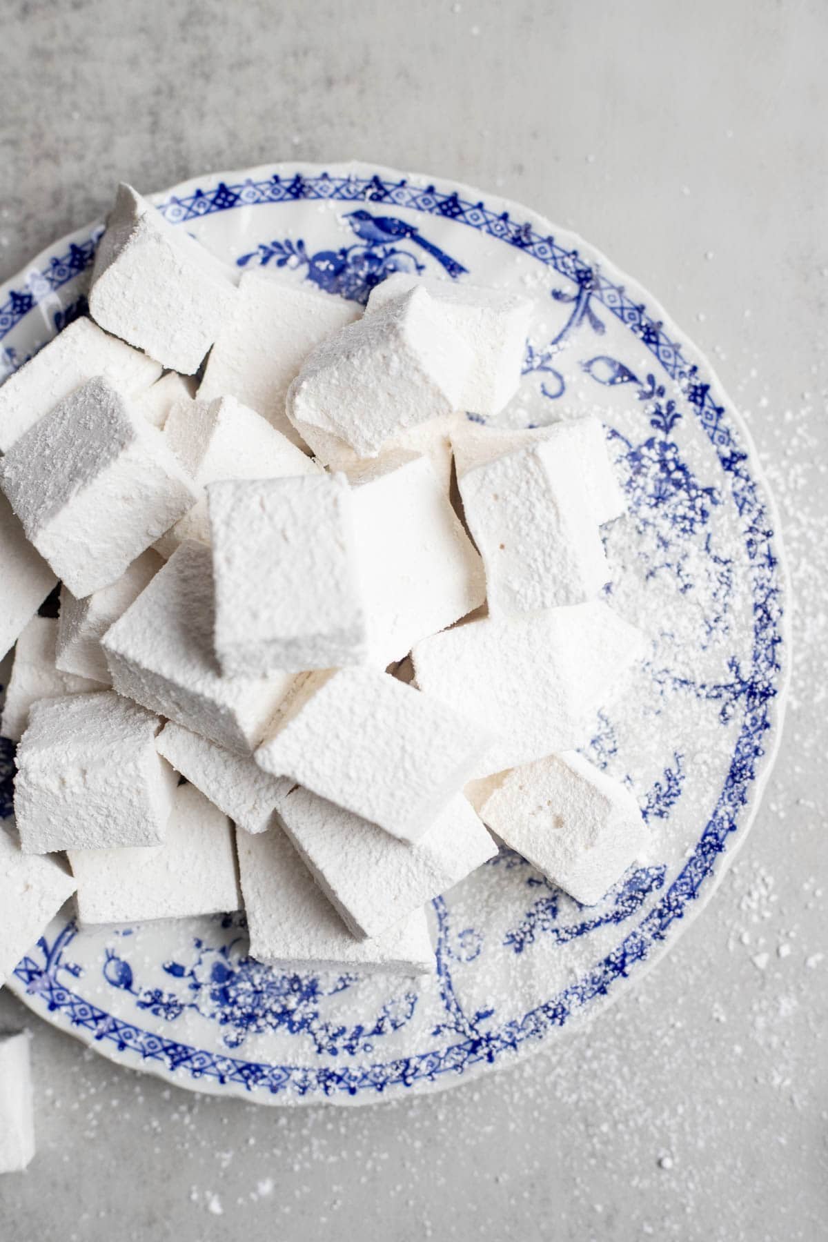 A pile of homemade marshmallows on a blue decorative plate.