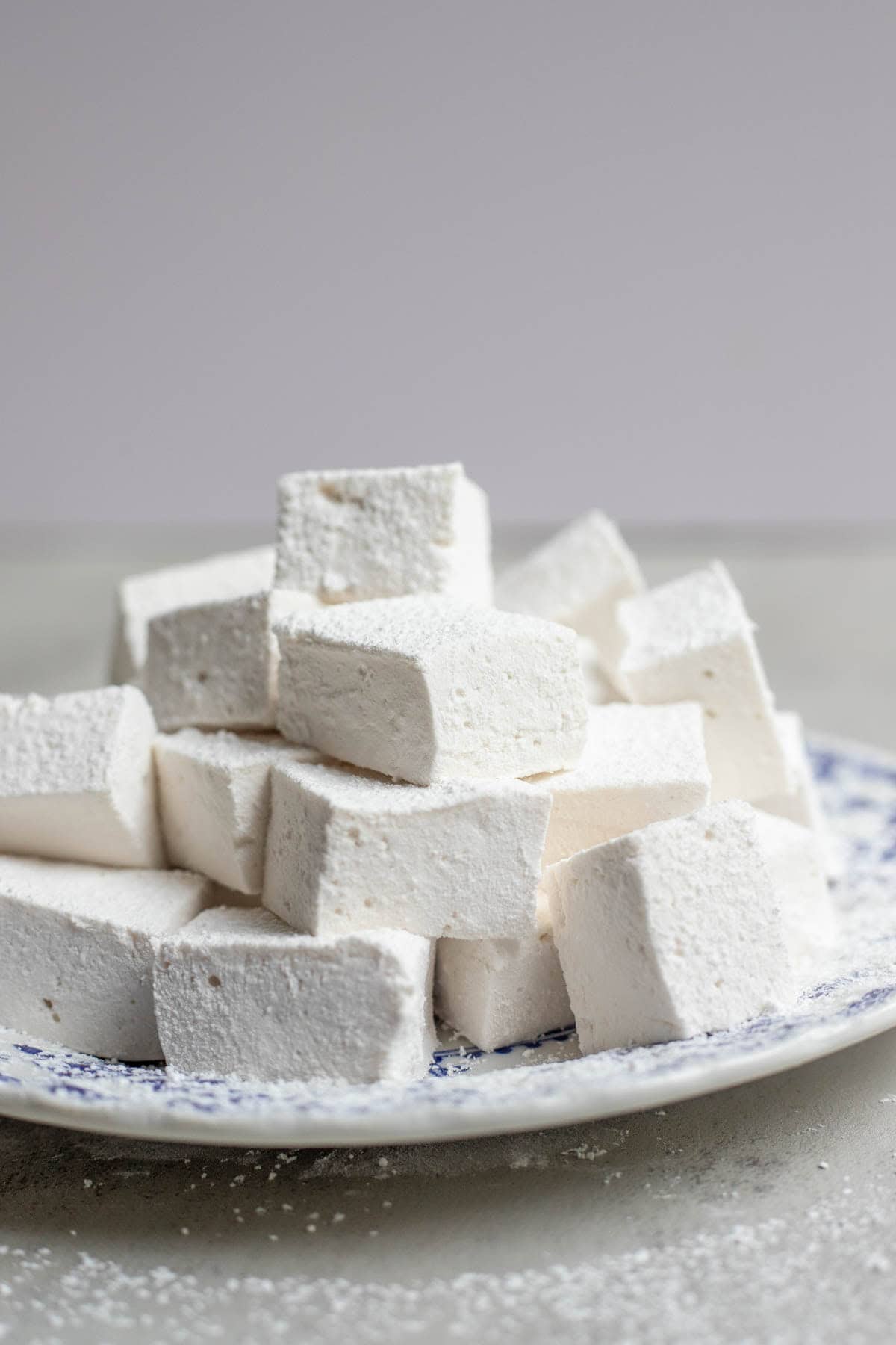 A stack of marshmallows on a decorative plate.