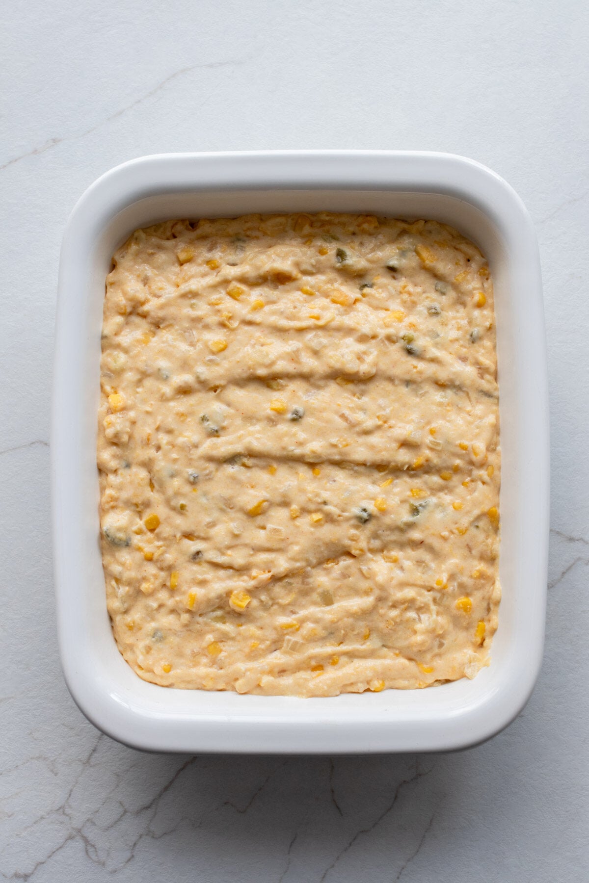 Corn casserole batter poured into a baking dish.
