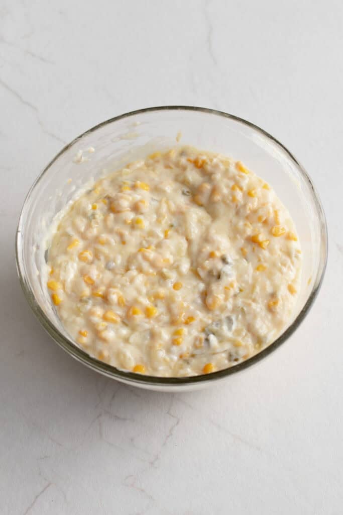 Dry ingredients folded into wet ingredients in a glass bowl.