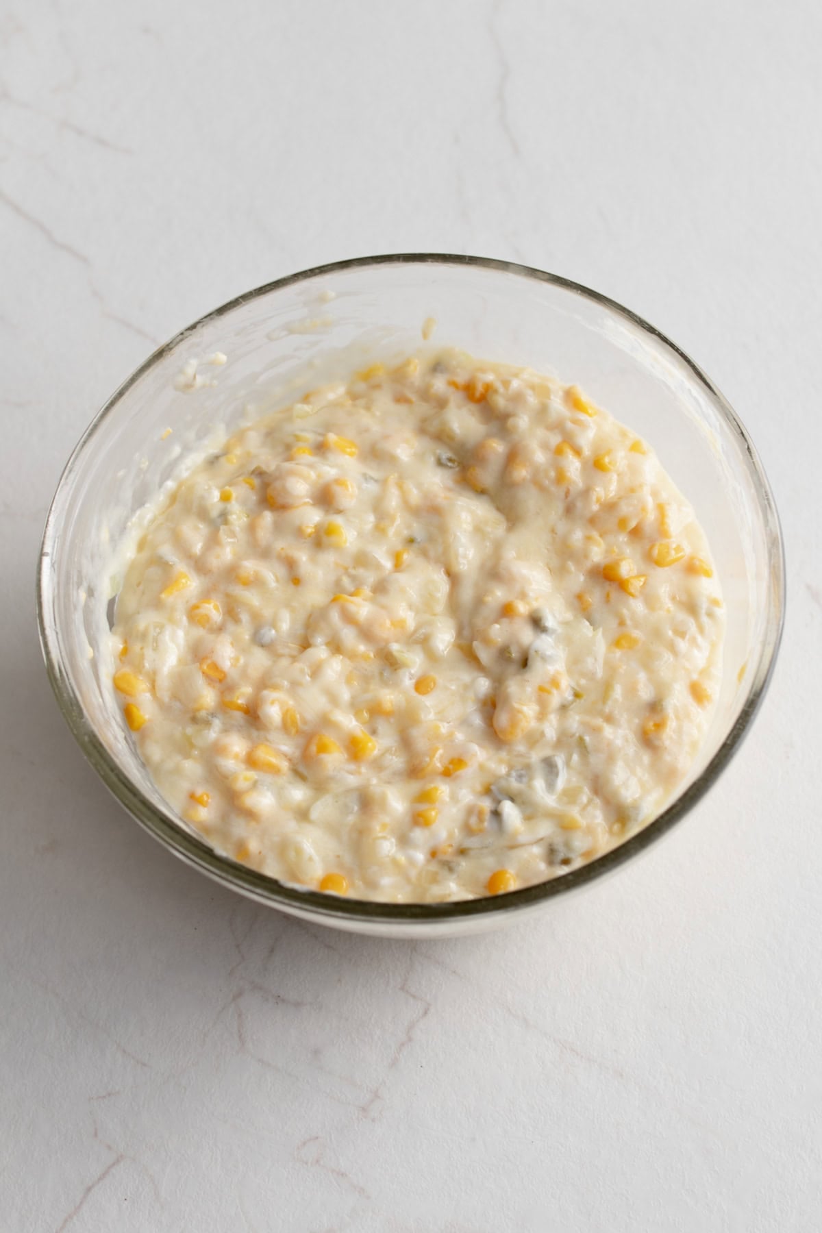 Dry ingredients folded into wet ingredients in a glass bowl.