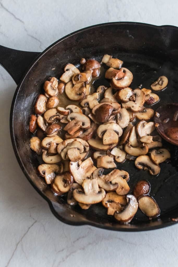 Cooking mushrooms in a cast iron skillet.