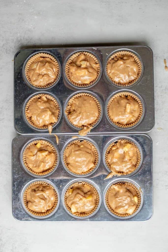 Cinnamon apple muffin mix in two muffin pans.