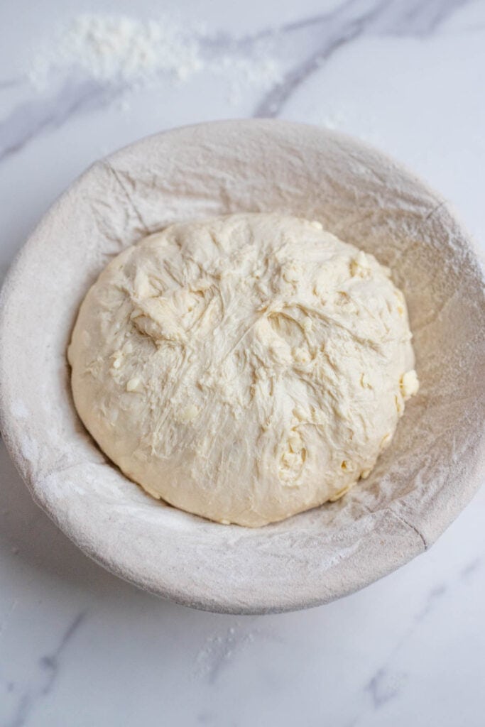 Sourdough croissant bread dough in a floured banneton basket.