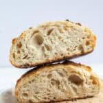 a sourdough boule cut in half stacked on top of each other.