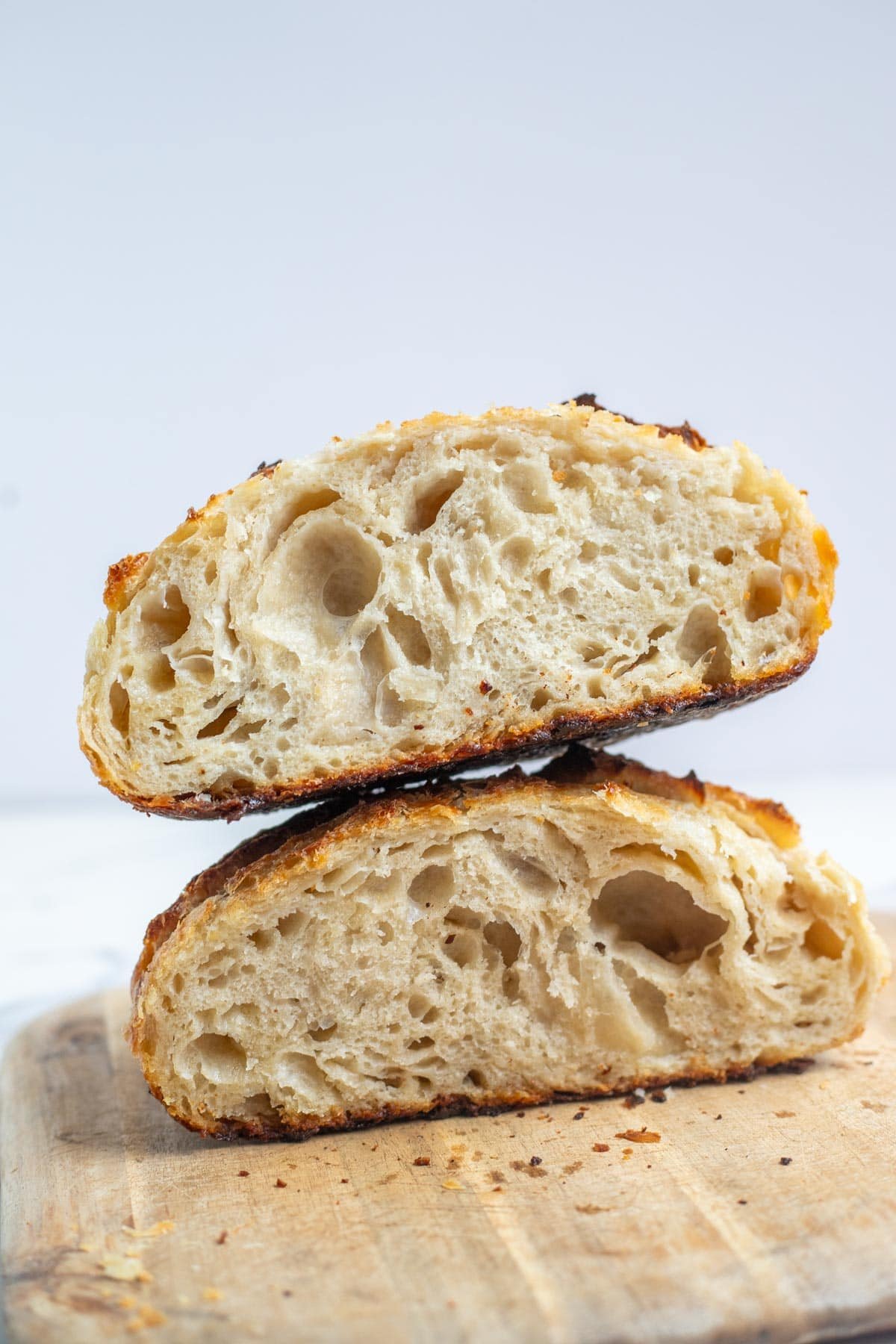 A sourdough boule cut in half stacked on top of each other.