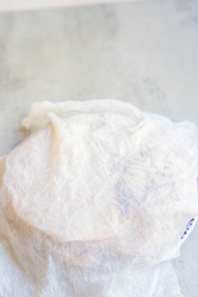 cooked tortillas covered by a white tea towel.
