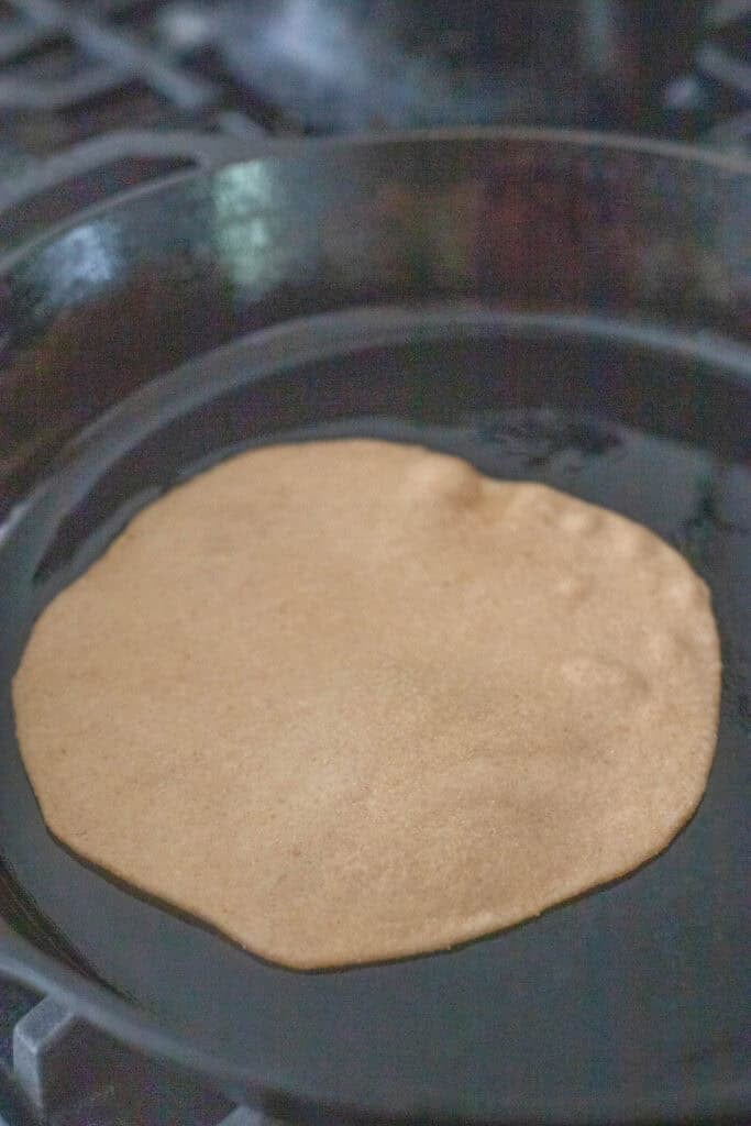 a tortilla cooking in a pan on the stove.