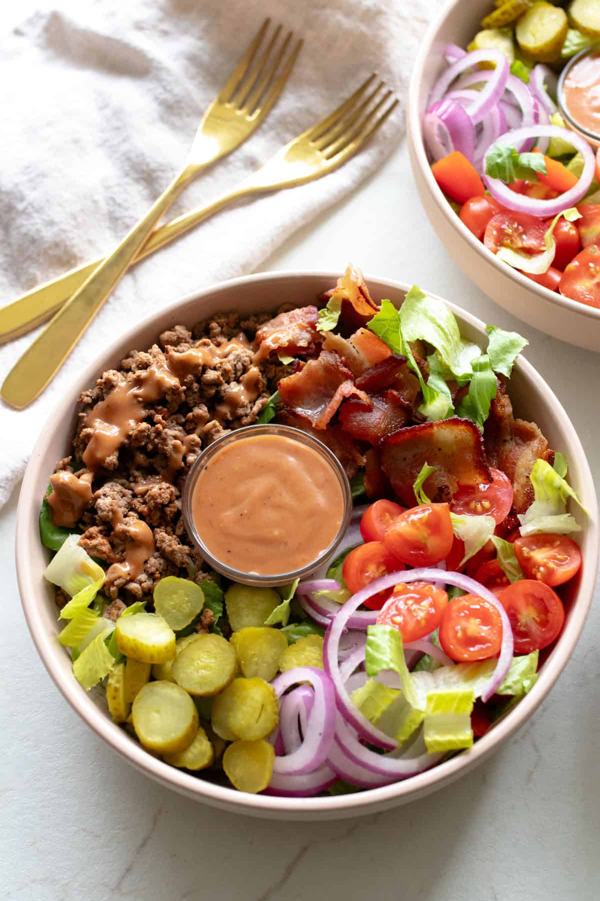 Bowl with burger ingredients and sauce.