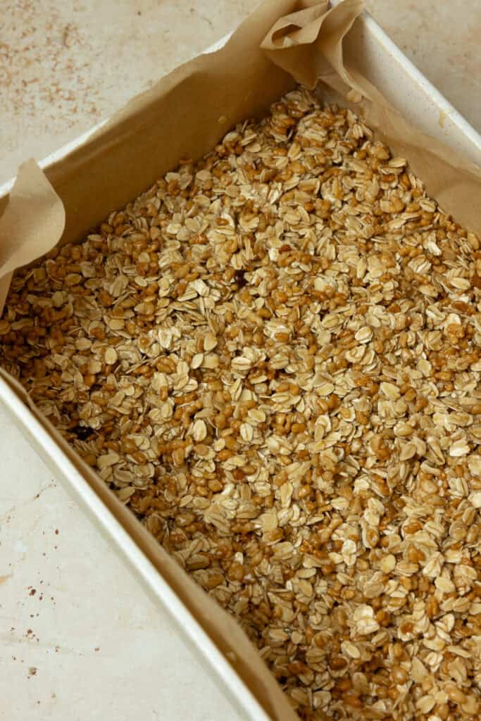 Granola mixture pressed into a pan.