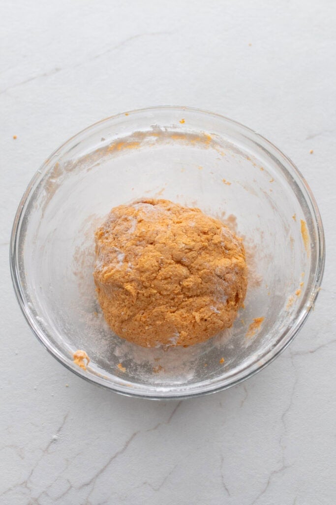 Pumpkin gnocchi dough in a glass bowl.