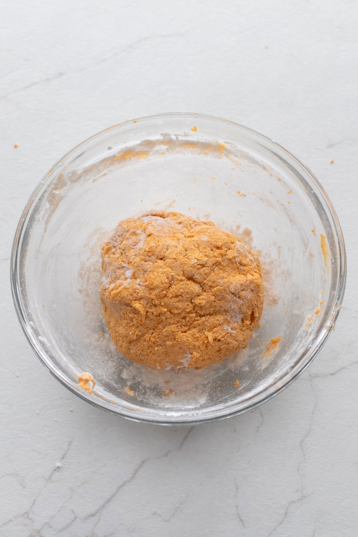 Pumpkin gnocchi dough in a glass bowl.
