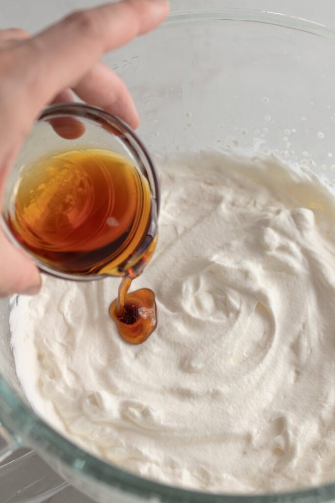 Adding maple syrup to whipped heavy cream.