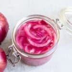 a glass jar of fermented red onions.
