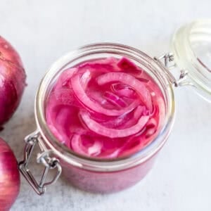 a glass jar of fermented red onions.