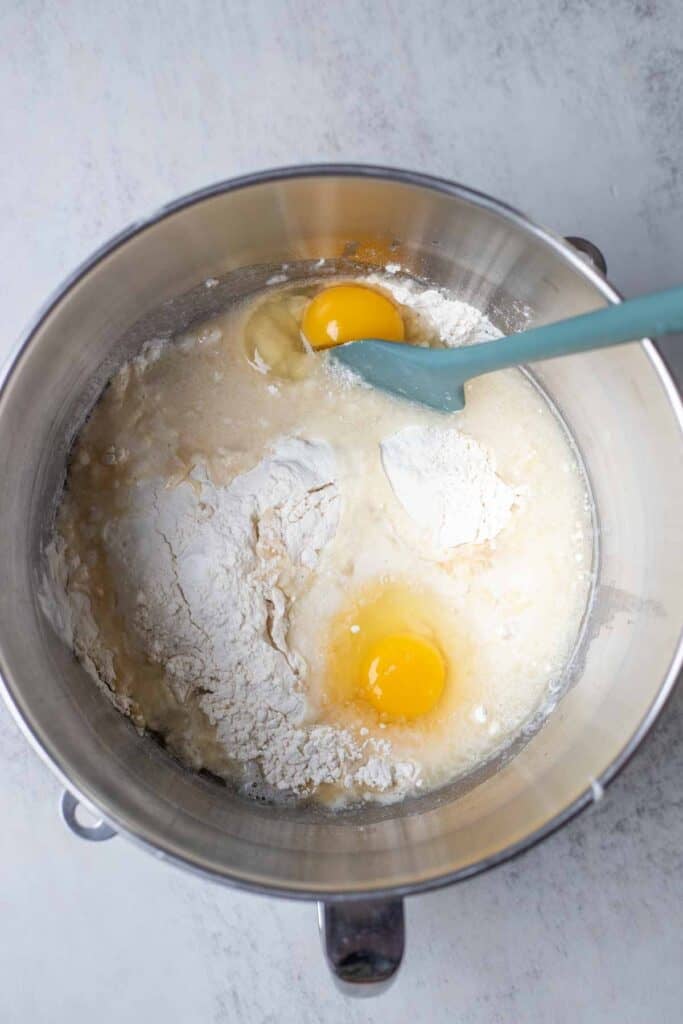 Flour, sourdough starter, oil, and eggs in a mixing bowl.