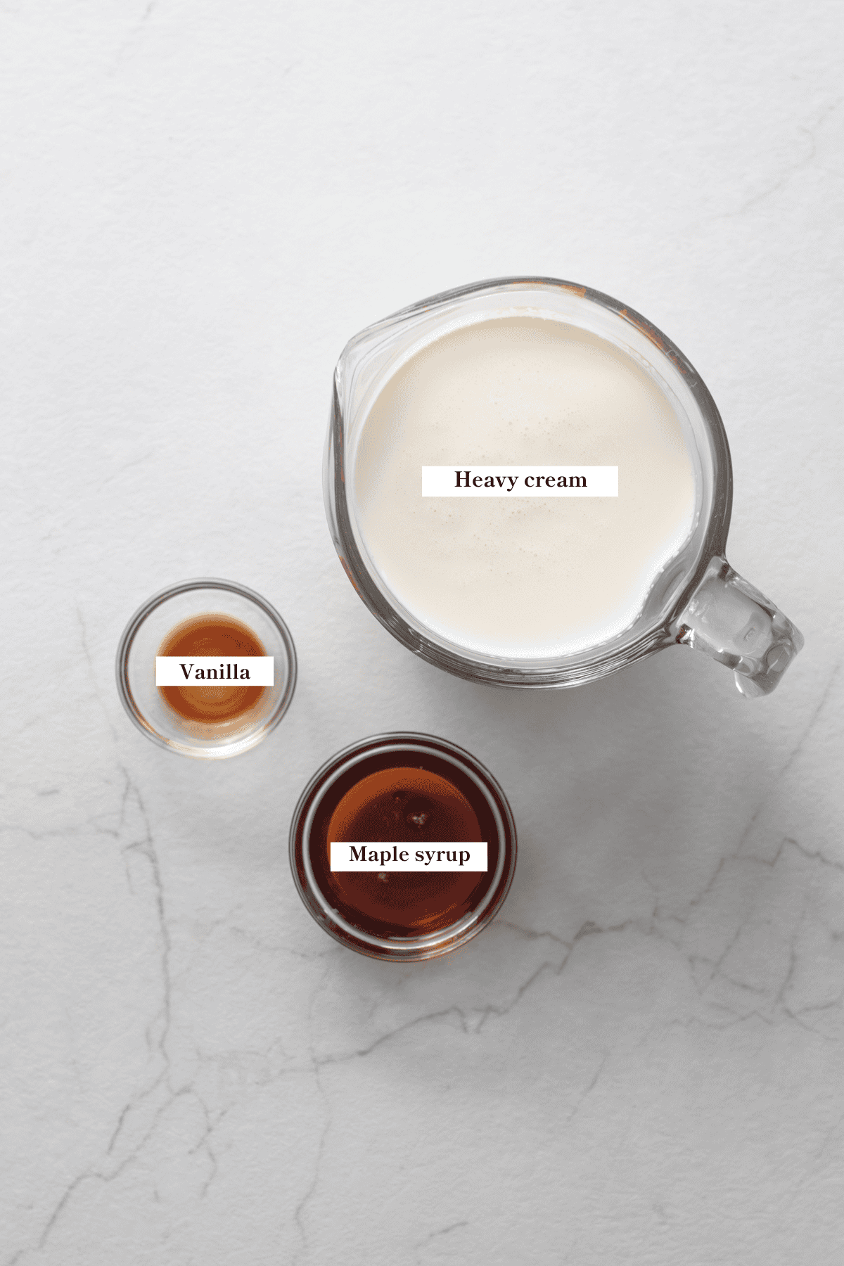 Cream, maple syrup, and vanilla extract in glass containers.