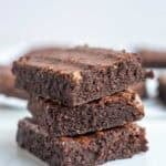 three whole wheat brownies stacked on top of each other on a kitchen counter top.