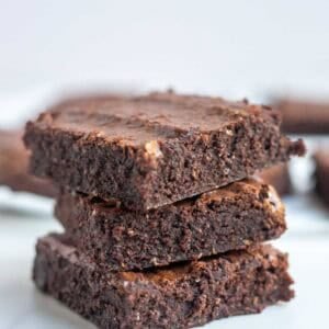 three whole wheat brownies stacked on top of each other on a kitchen counter top.