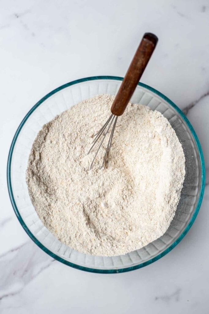 Dry ingredients in a bowl with a whisk.