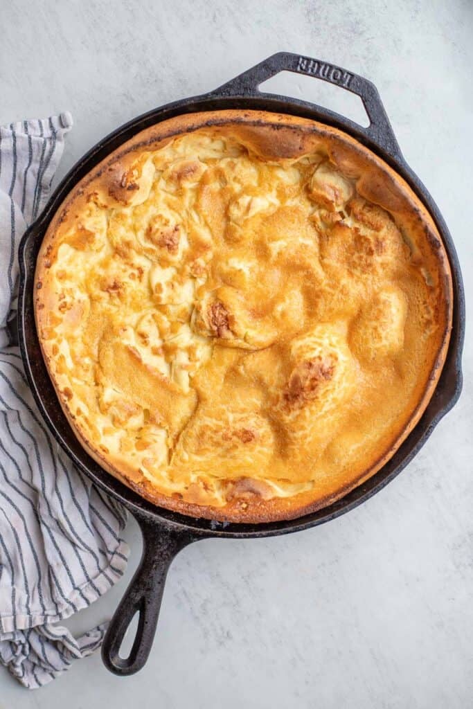 A Dutch baby pancake cooked in a cast iron skillet fresh from the oven.