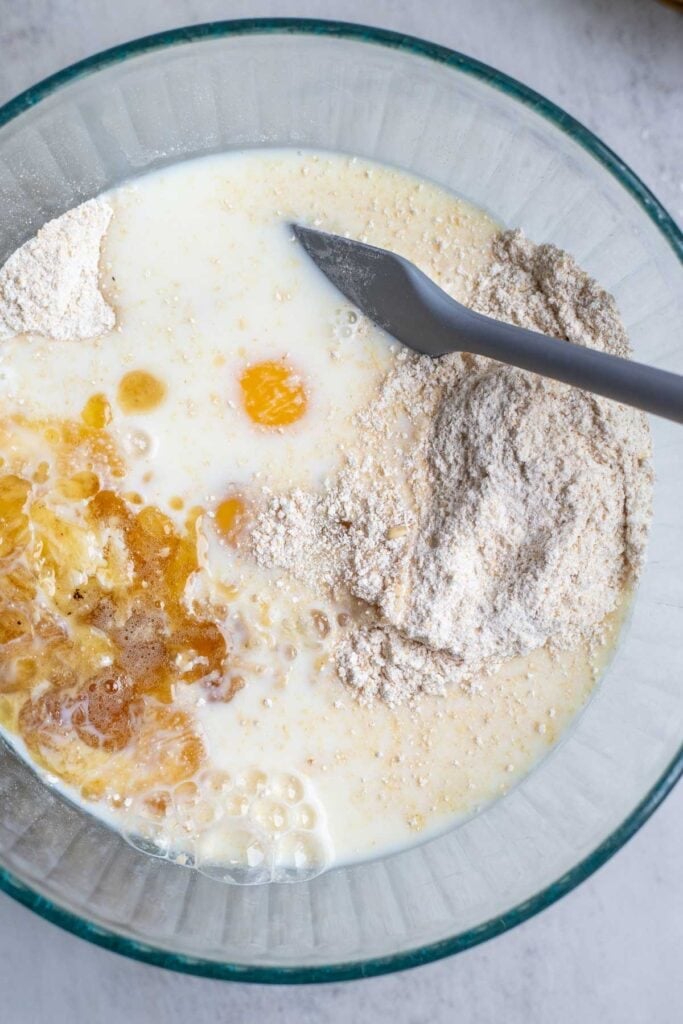 Eggs, milk, and vanilla added to the dry ingredients in a glass mixing bowl.