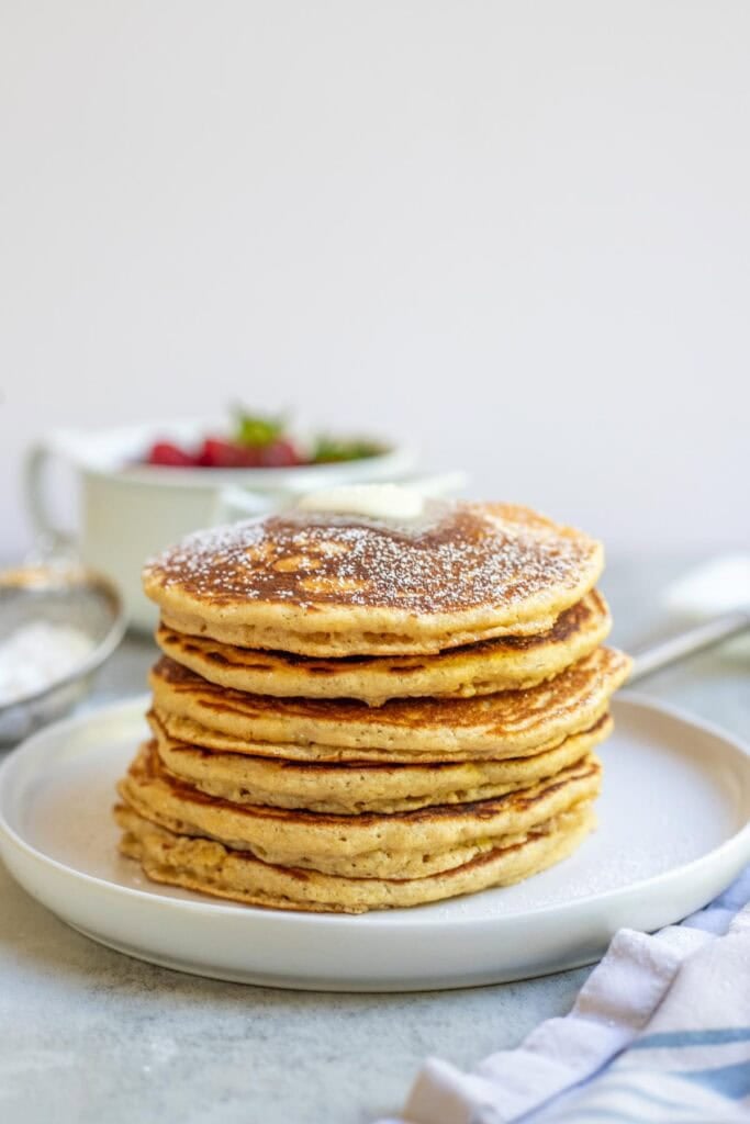 A stack of whole wheat pancakes on a serving plate.
