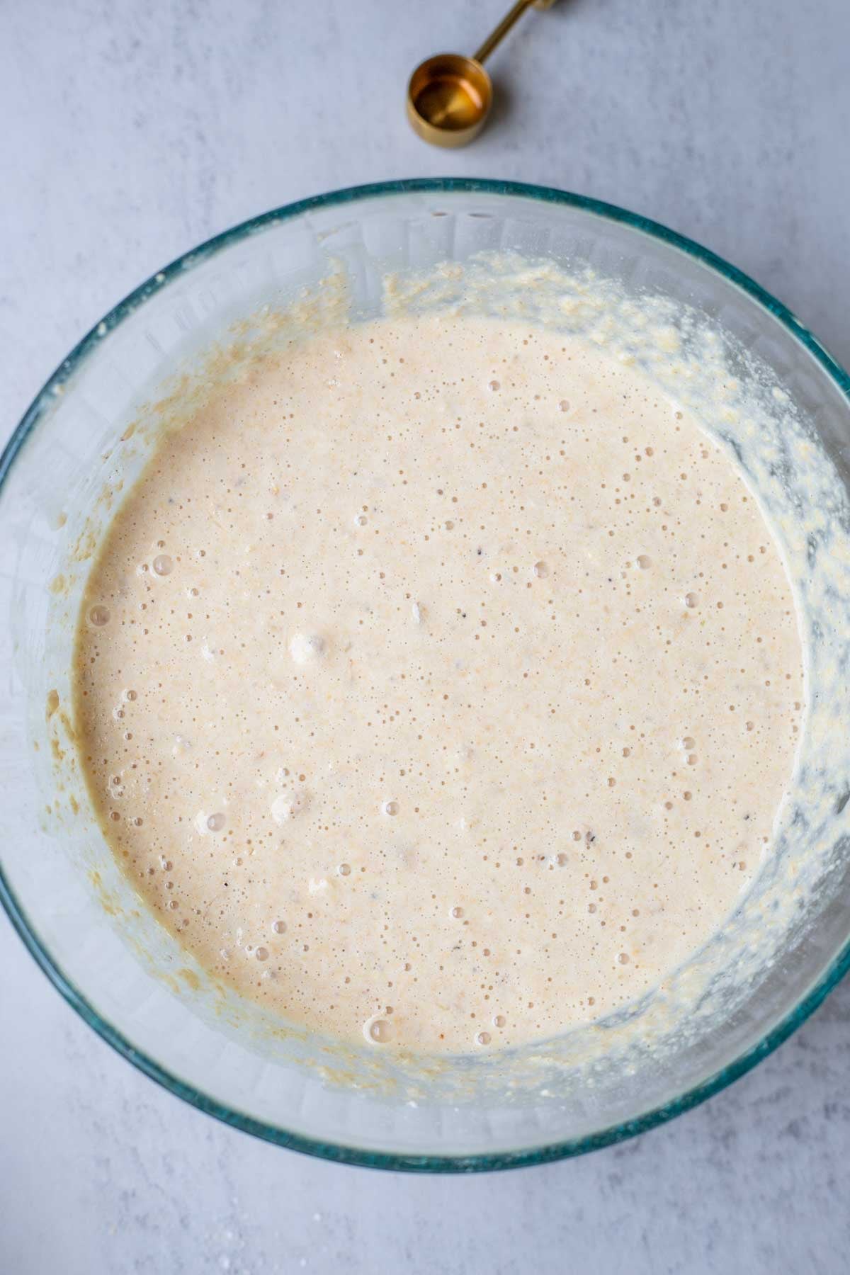 Whole wheat pancake batter in a glass bowl resting.