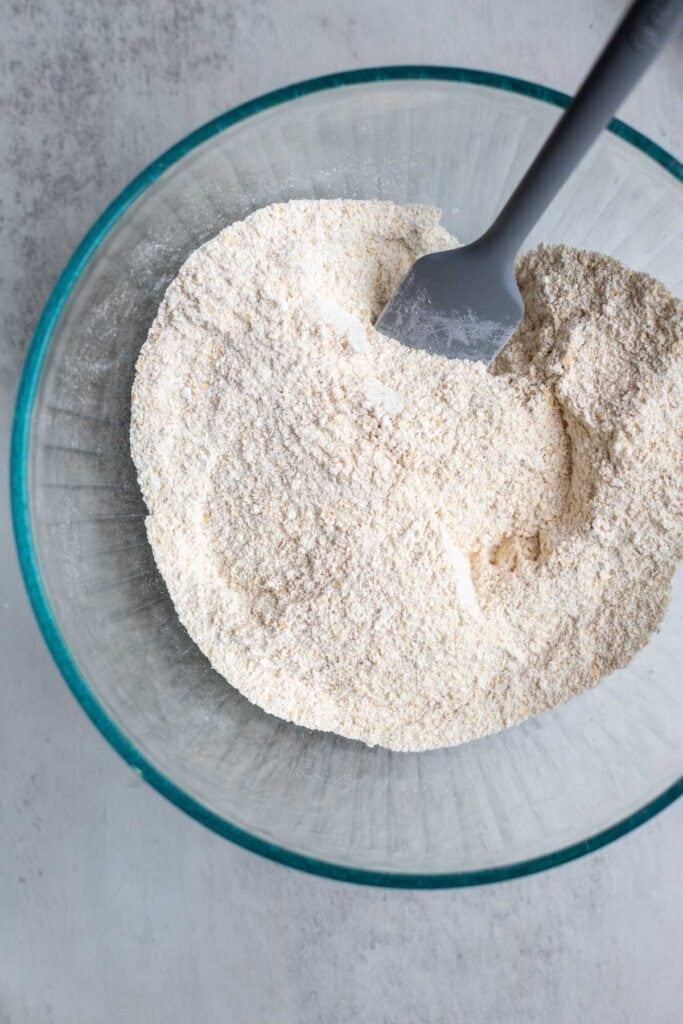 Flour, sugar, baking powder, and salt in a glass mixing bowl.