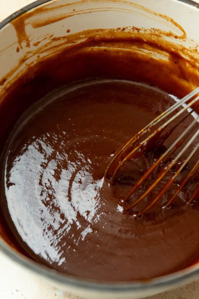 Sauce in a pan with a whisk.
