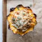 Baked stuffed acorn squash on a baking sheet.