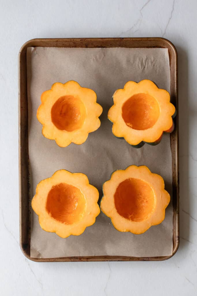Acorn squash on a baking sheet.