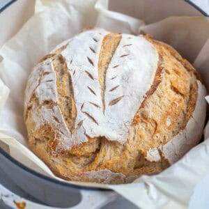 a boule of sourdough bread in a dutch oven.