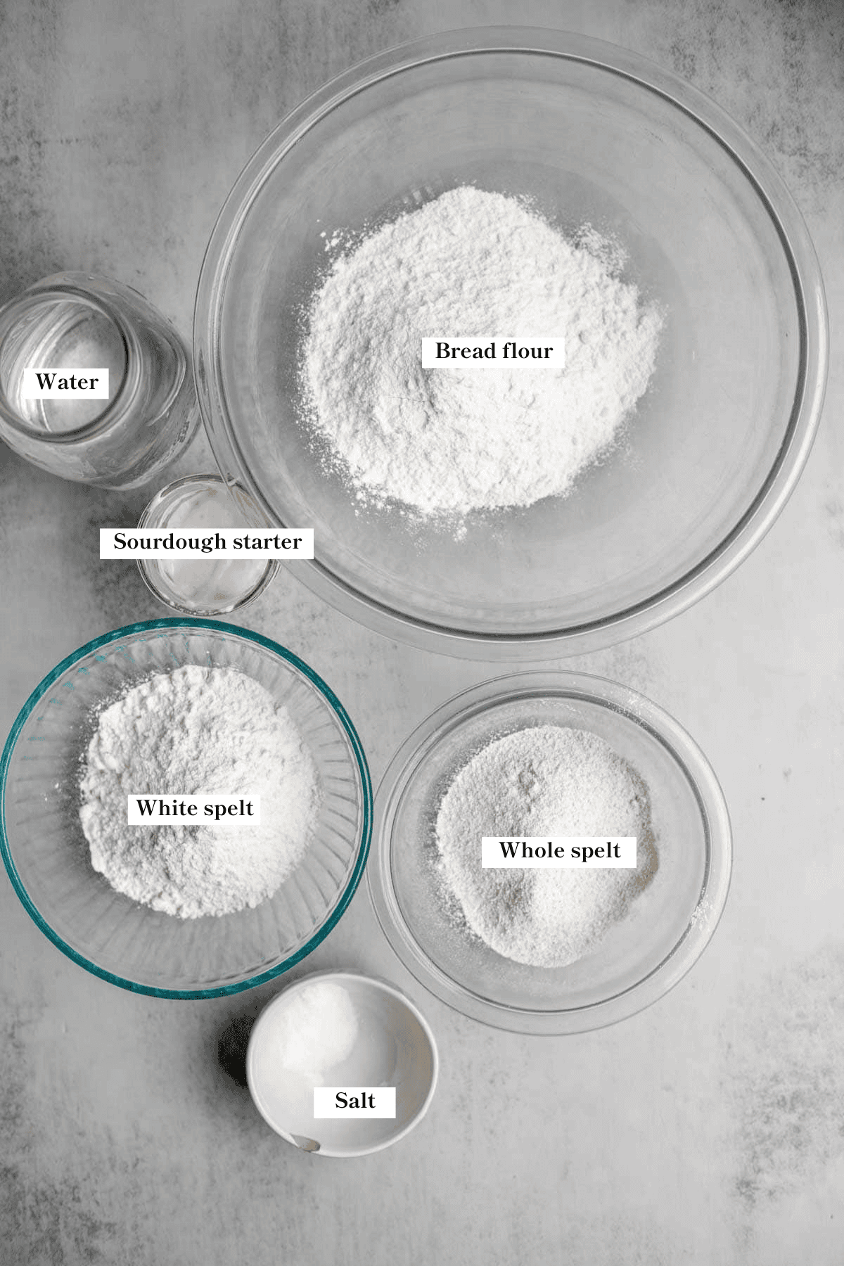 Spelt, bread flour, salt, water, and sourdough starter on the counter.