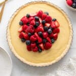 a custard in a tart pan topped with fresh berries.