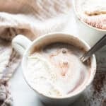 a white mug filled with bone broth hot chocolate and topped with home made whipped cream.