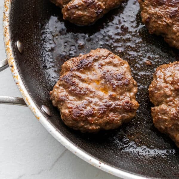 Sausage patties in a skillet.